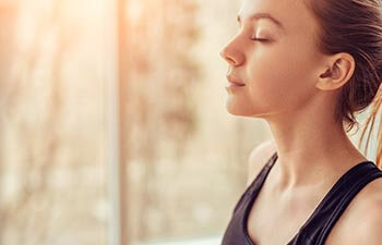 young female with closed eyes breathing deeply